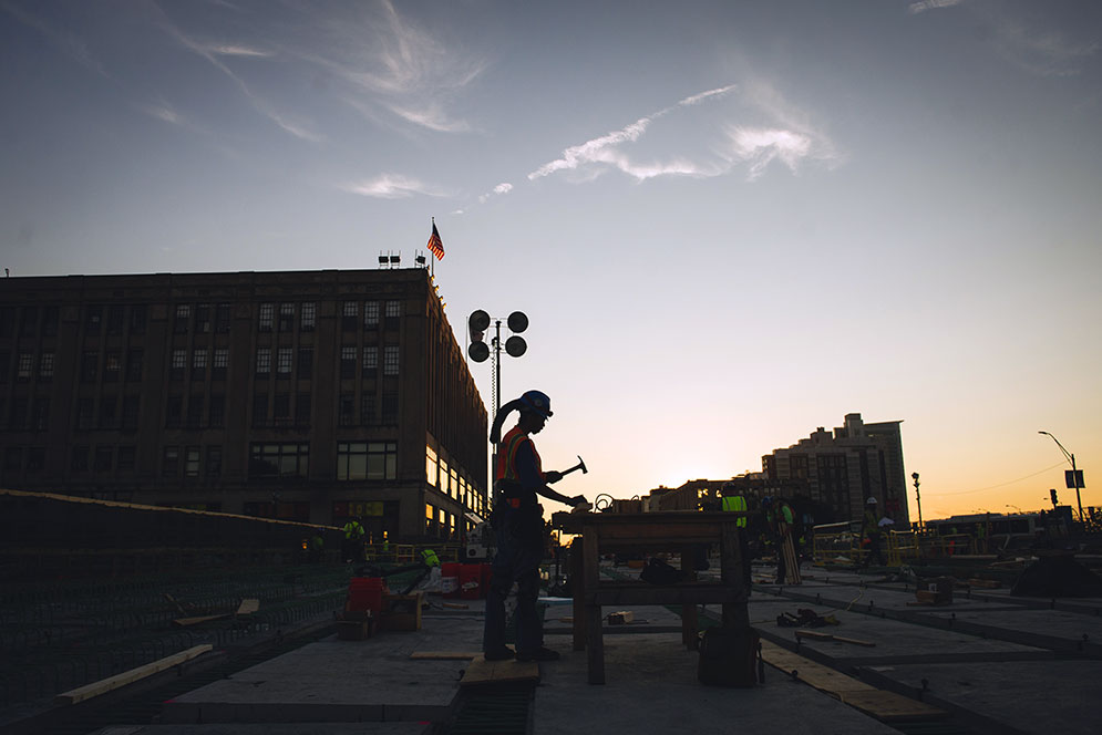 Silhouette of a man working on construction on Commonwealth ave at twilight.