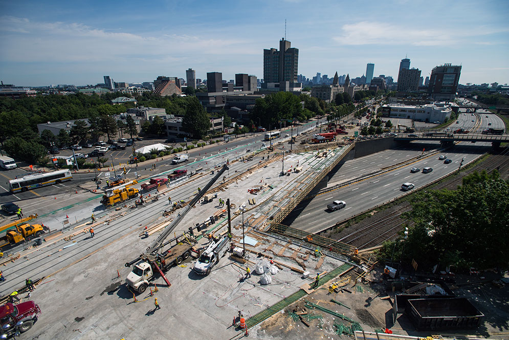 Aerial view of bridge progress with Boston city skyline in the distance