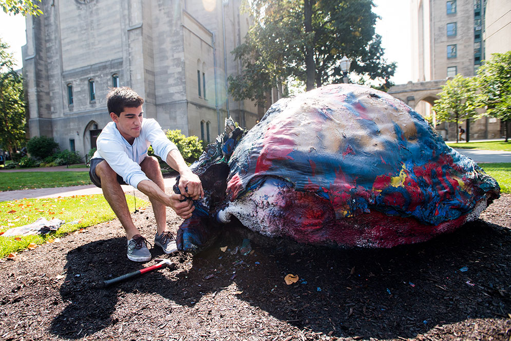 Nico Pache (CAS'20), a member of Kappa Sigma gives the fraternity rock some much needed TLC