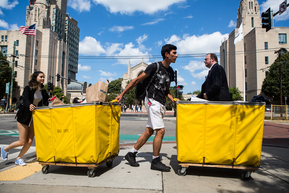 Students wheel carts down Commonwealth Ave. during Fall Move In