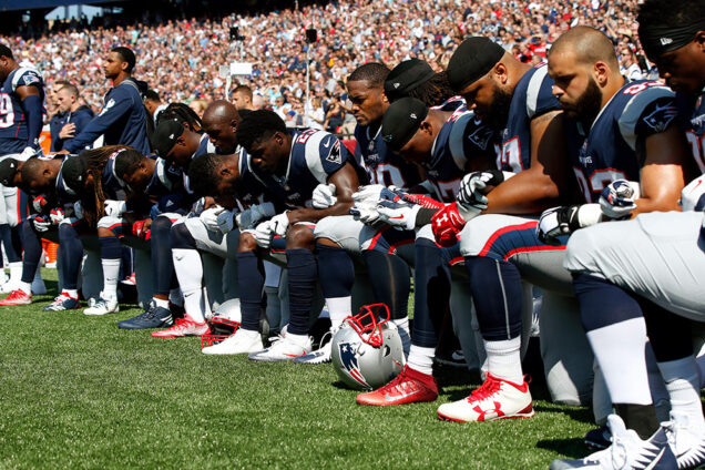 New England Patriots players kneel during the United States National Anthem