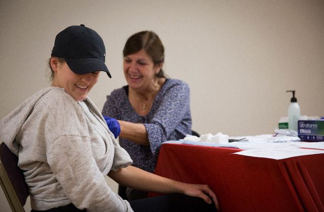 Dana Doherty, a local registered nurse, prepares to administer a flu shot to Clare Murphy (SAR GRS 