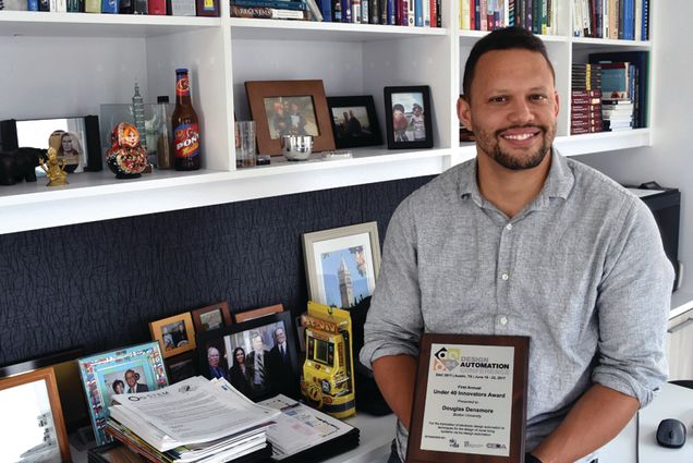 Douglas Densmore holds award