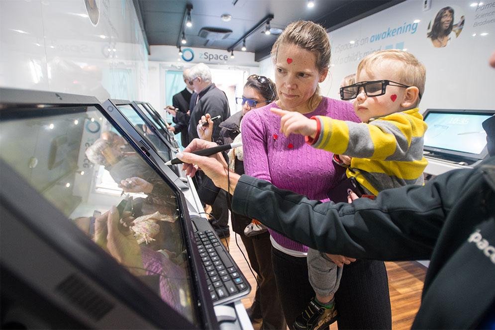 A mother and child explore the zSpace augmented and virtual reality mobile educational classroom.