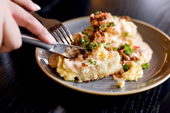 The biscuits come slathered with a fontina cheese–based gravy, topped with house-made sausage and chives. Photo by Maddie Malhotra (COM’19)