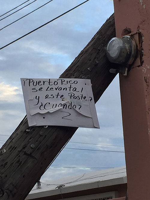 A Puerto Rico Se Levanta sign hung on a telephone pole reads Puerto Rico will rise again—or get up. But how about this pole?
