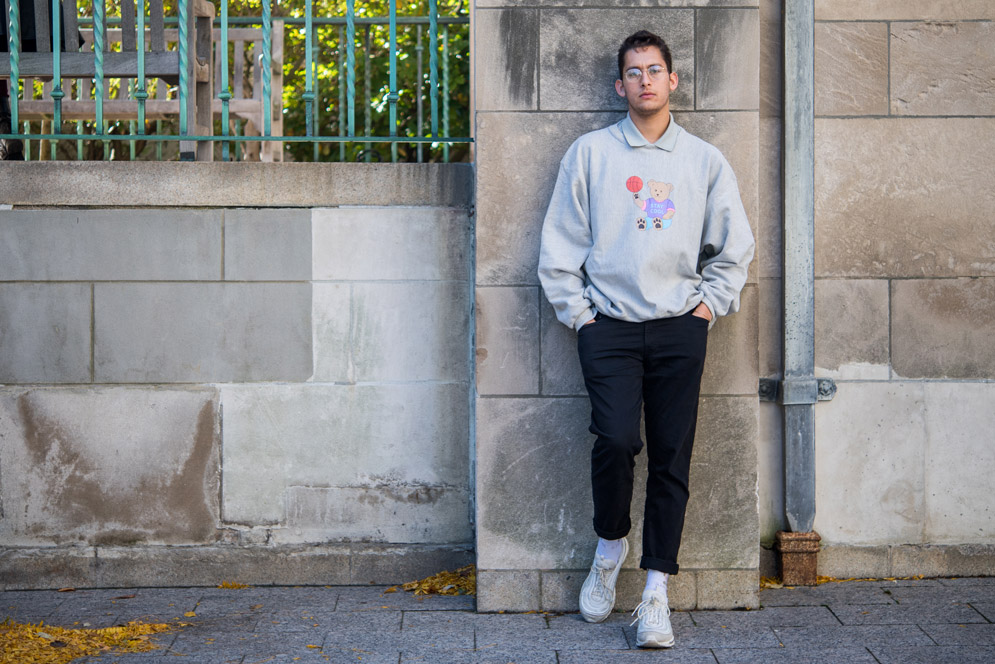 Amin poses in a grey sweatshirt from his clothing line.