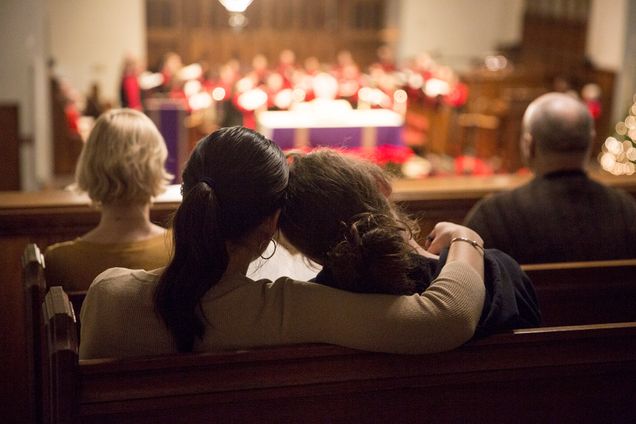 Two people hug while listening to the Annual Service of Lessons and Carols in the Marsh Chapel. 