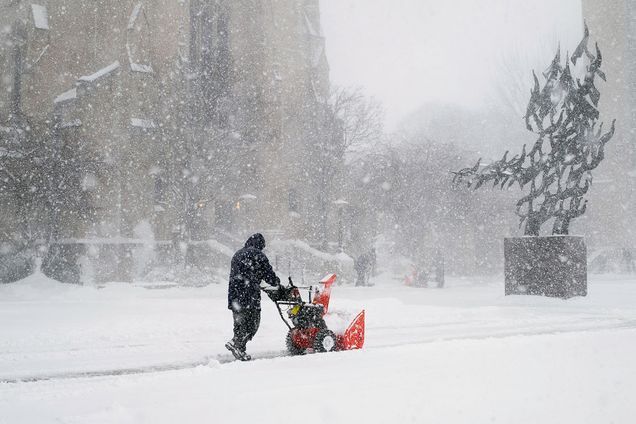 A BU worker plows snow near Marsh Plaza.