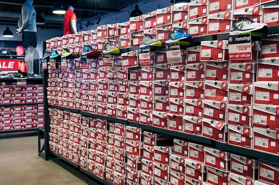 Shoe boxes fill shelves at the New Balance Factory Store in Boston