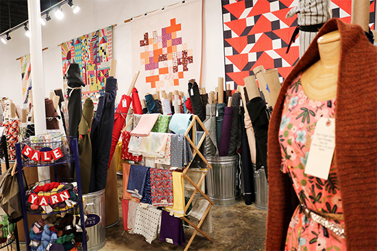 Yarn and textile materials displayed on the floor of Gather Here store in Inman Square, Cambridge, MA