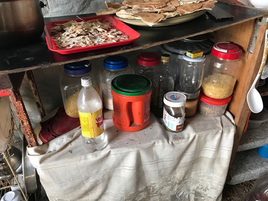 Stored food on a shelf in the kitchen of a tent in a Syrian refugee camp in Lebanon