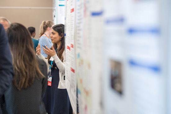 Researchers discussing work at the Health Equity Symposium poster session. 