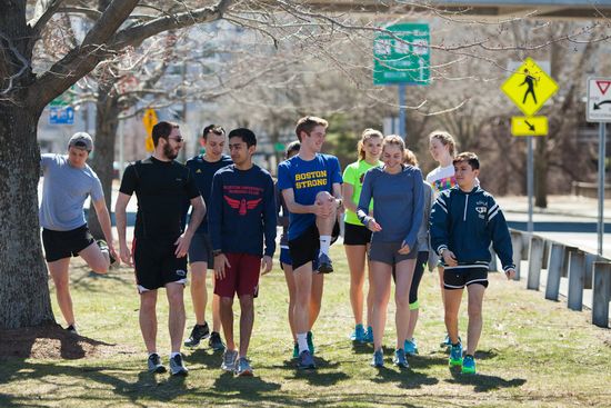 The BU Running Club warms up by stretching