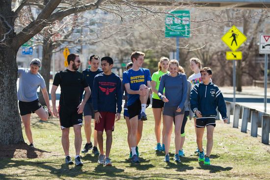 The BU Running Club warms up by stretching