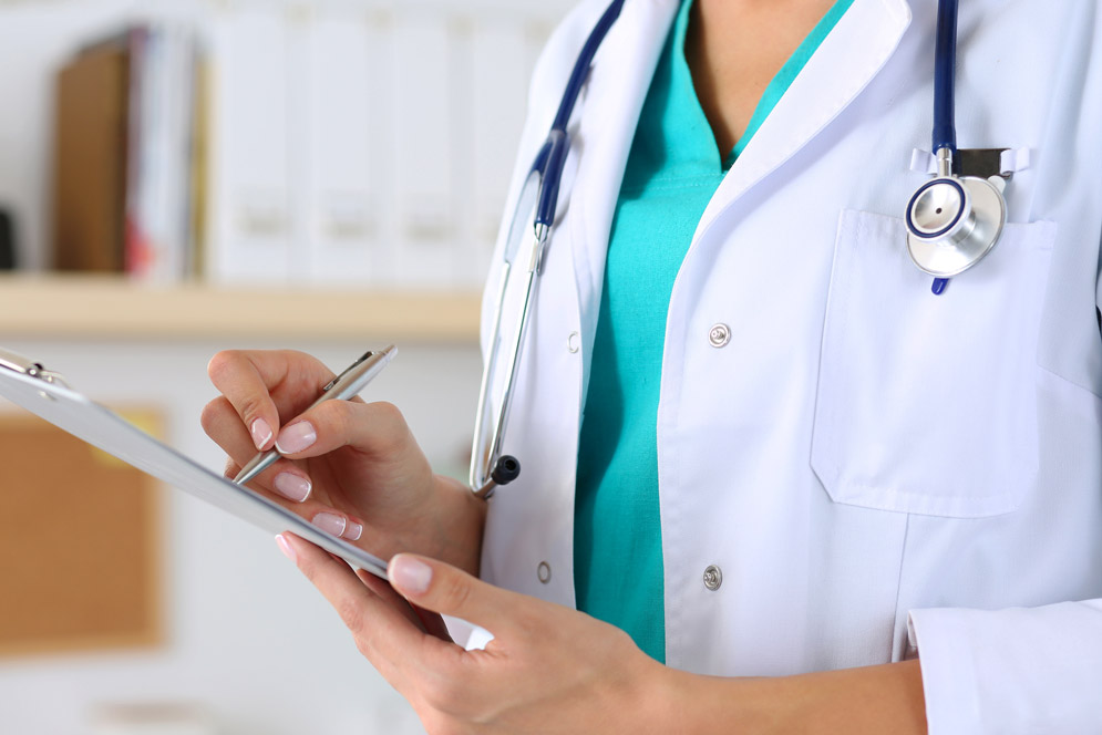 A medical student writes using a clip board