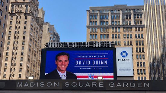 A digital billboard at Madison Square Garden shows a photo of new NY Rangers coach David Quinn