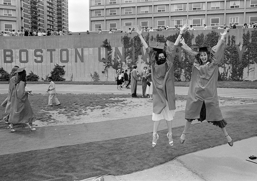 Two graduates celebrate after Commencement on Nickerson Field on May 16, 1982.