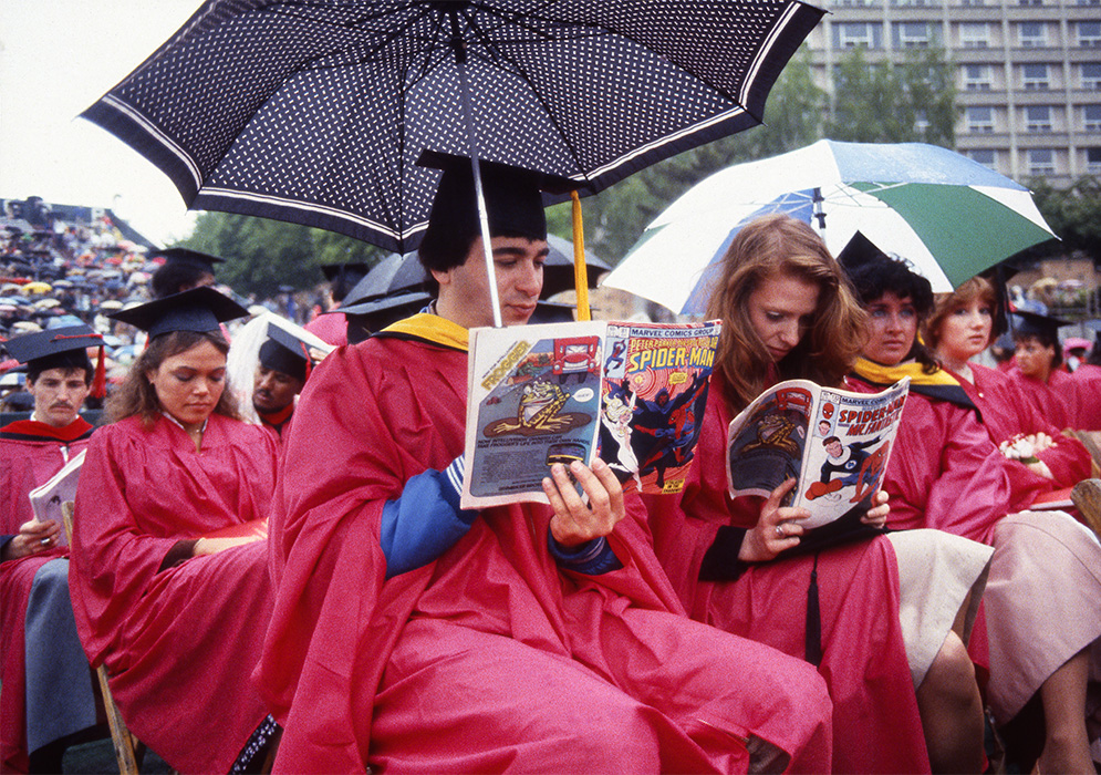 Graduates read comic books during the BU Commencement on Nickerson Field, May 15, 1983.