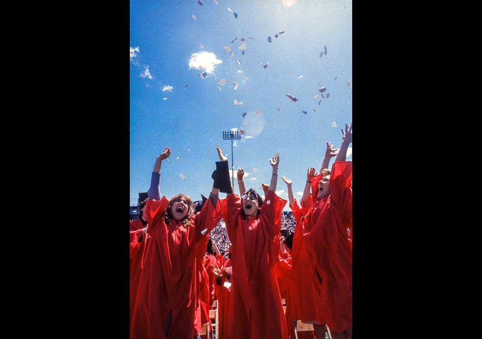 Graduates celebrate by throwing paper into the air during Commencement on May 13, 1984.