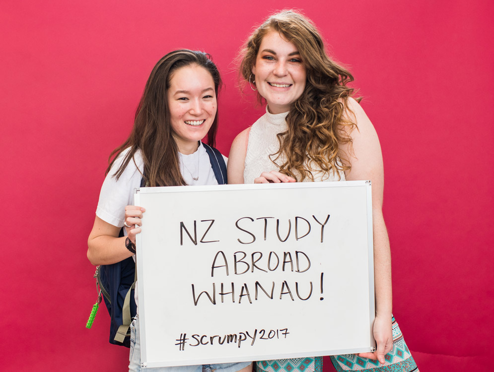 BU students hold a sign saying NZ Study Abroad Whanau!