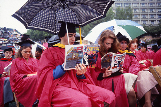 Graduates read comic books during the BU Commencement on Nickerson Field, May 15, 1983.