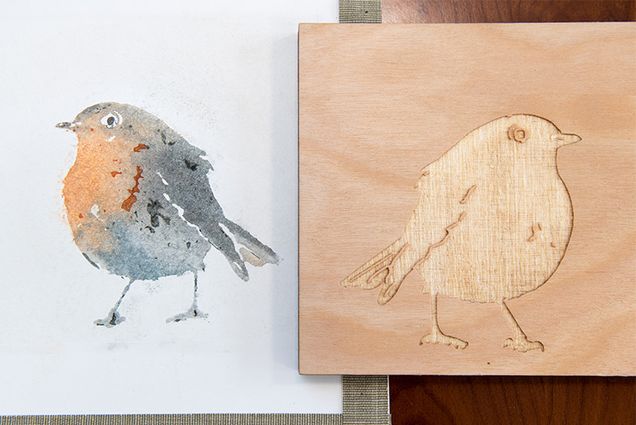 A detailed watercolor of a bird next to the laser-etched wood panel used to print the watercolor.