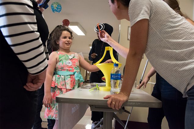 A BU student shows a gyroscope to a child at the Space Science for Kids event.
