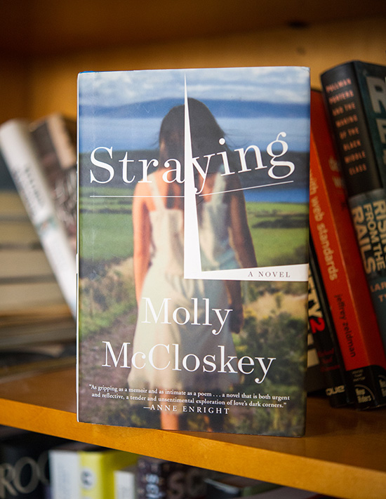 The fiction novel Straying by Molly McCloskey perched on a book shelf
