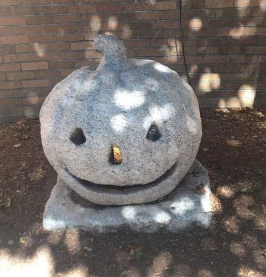 A stone statue of a pumpkin jack-o-lantern