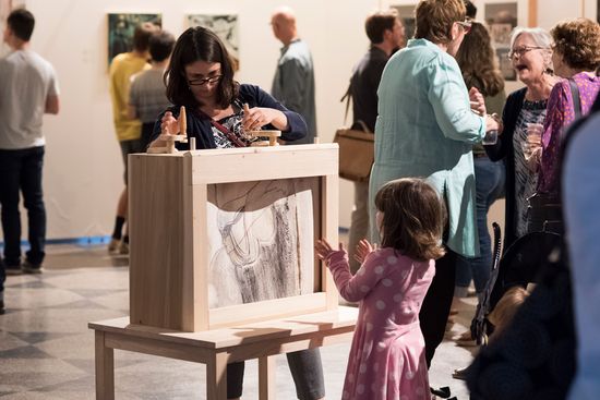 People mill about the "A Few Conversations Between Women" exhibit