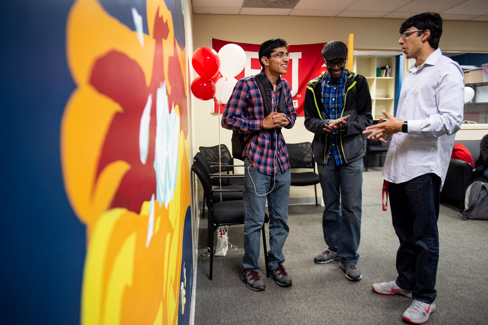 Students study the new mural in the student government office 