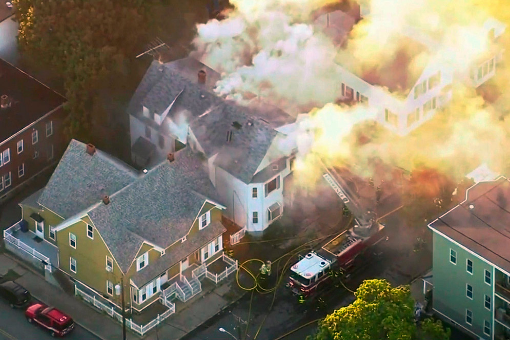 Firefighters battle flames leaping from a home after a series of gas explosions in Lawrence, Mass.