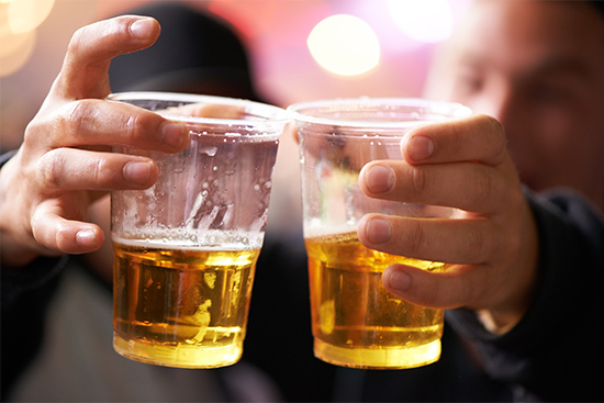 Two guys drink beer at a college party