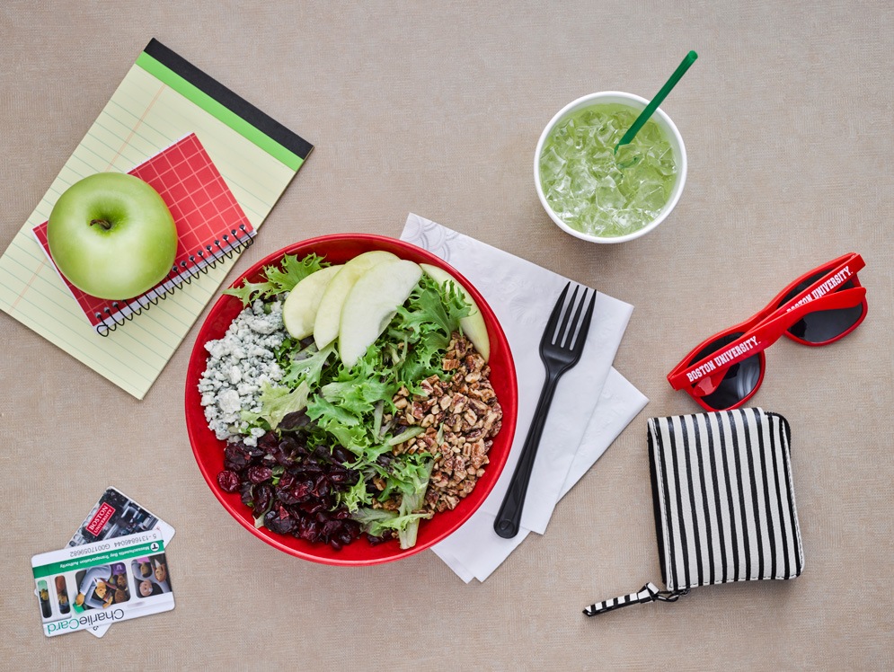 A beautiful salad A beautiful salad sits on the table alongside other miscellaneous items