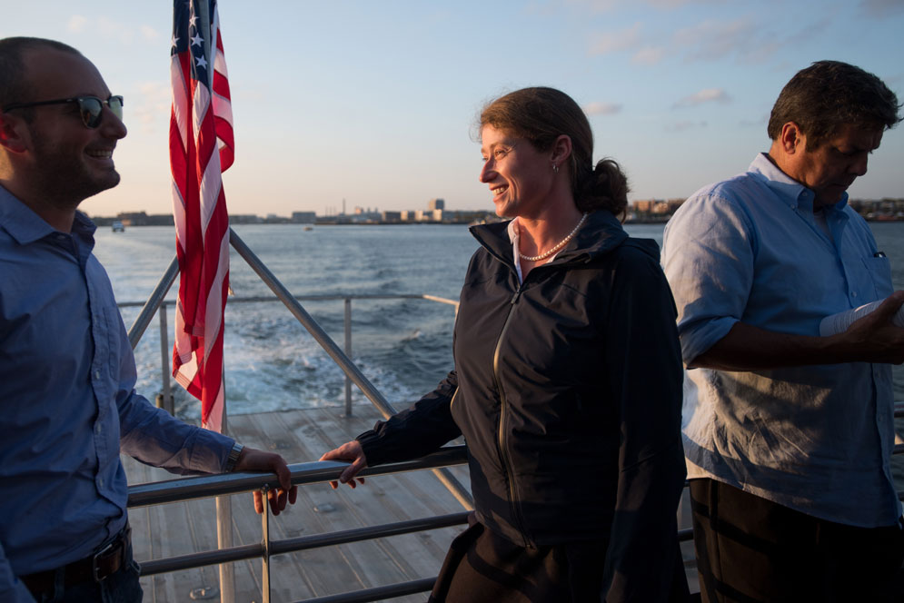 Woman commuting on a Boston Harbor ferry talking to a companion