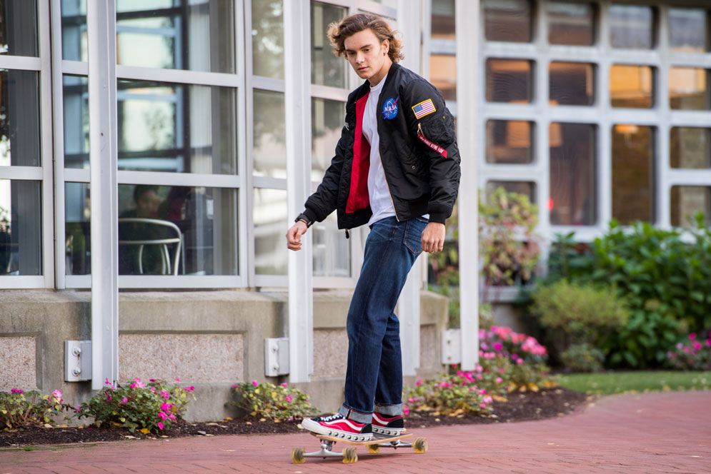 Student riding a longboard around campus