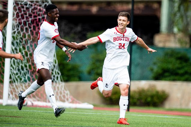 Members of the Men's soccer team high five after a goal