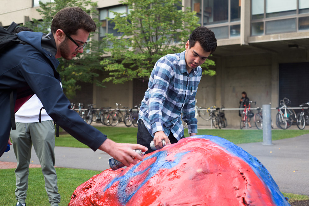 Members of Chi Pai paint the symbol of the pledged fraternity onto the frat rock