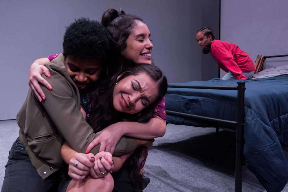 Actors embrace in the play "The Tragic Ecstasy of Girlhood"