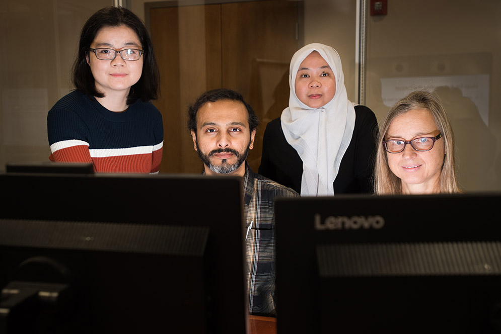 Photo of Lei Guo, from left, Prakash Ishwar, Derry Wijaya, and Margrit Betke in front of computer monitors.