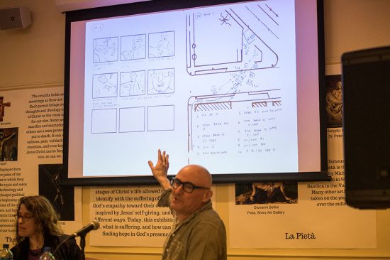 Breaking Bad director Adam Bernstein explains a Breaking Bad scene diagram projected on a screen behind him.