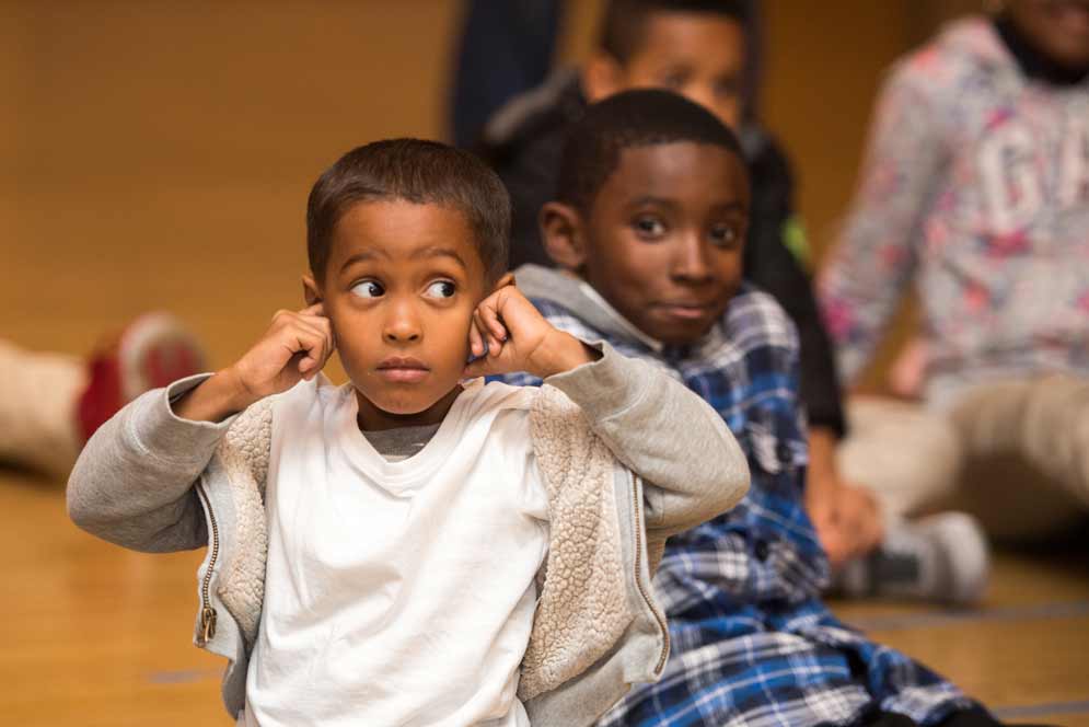 A kid covers his ears during the After-School Music program