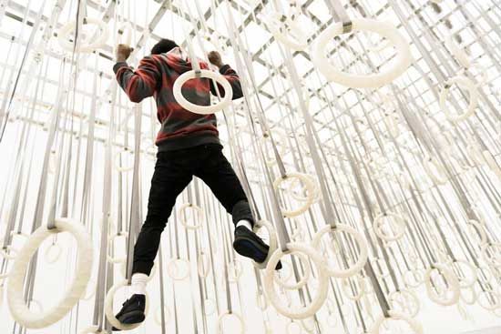 someone swings from the ceiling on gymnastic-style rings