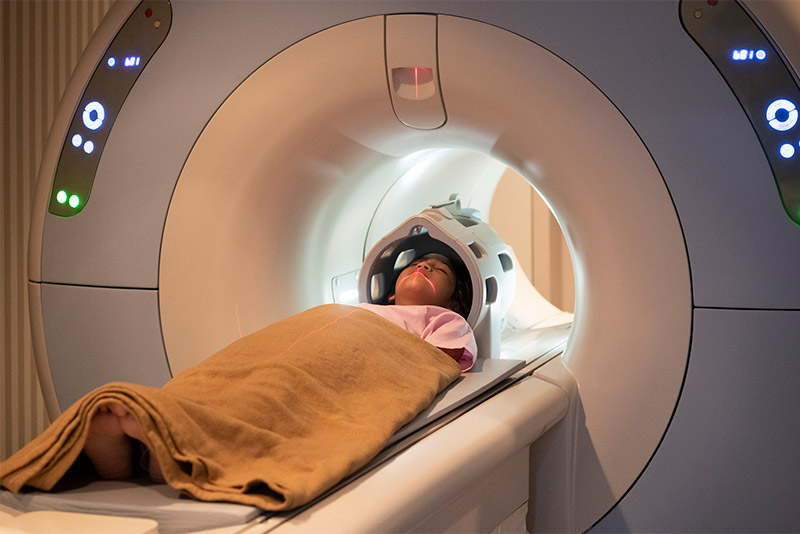 A female asian child enters an MRI machine.