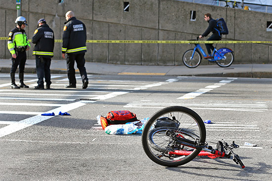 A bicycle and bike helmet involved in an accident when a biker was hit by a truck Friday, November 9 lie on the road in a taped off accident scene by the Museum of Science