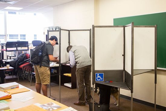 A student and older man vote in the midterm election at booths in the 111 Cummington Mall polling place on November 6, 2018