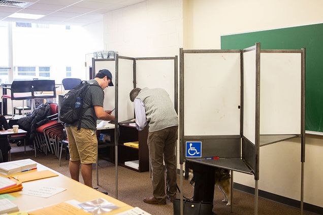 A student and older man vote in the midterm election at booths in the 111 Cummington Mall polling place on November 6, 2018