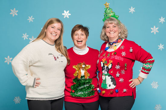 three women pose in their ugly holiday sweaters