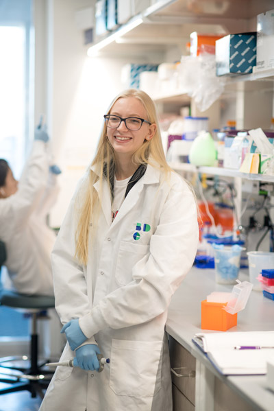 Petherbridge poses in the lab wearing a white lab coat